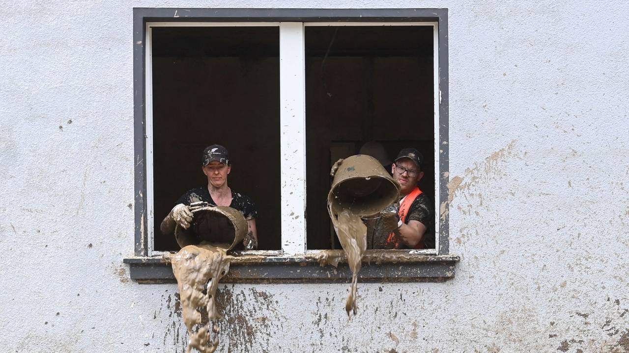 Unmittelbar nach der Flut kippen Helfer Schlamm aus Eimern in einem Haus in Dernau (Ahrtal)