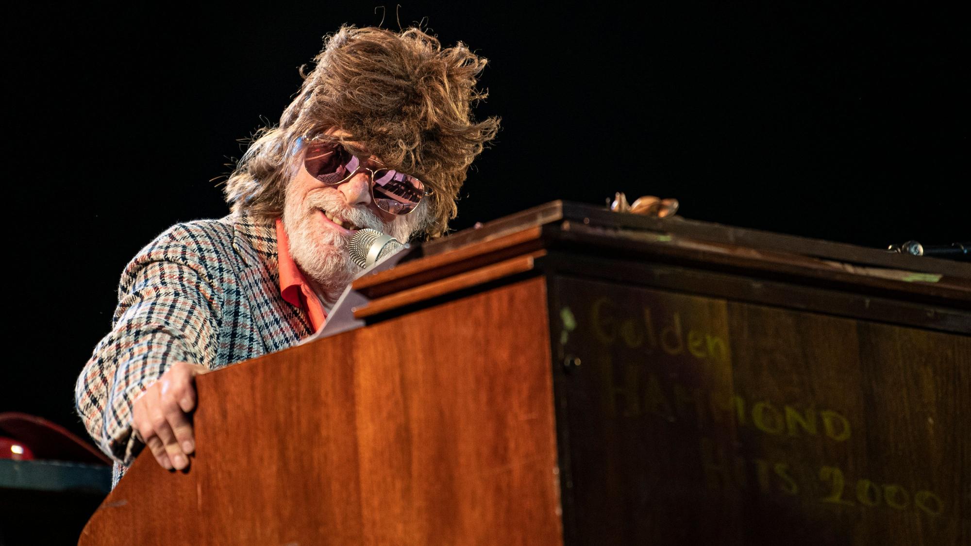 Helge Schneider steht während eines Konzertes auf der Waldbühne an einem Pult.