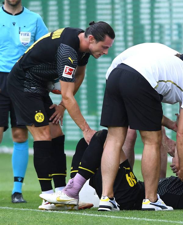 Marius Wolf liegt mit schmerzverzerrtem Gesicht auf dem Rasen.