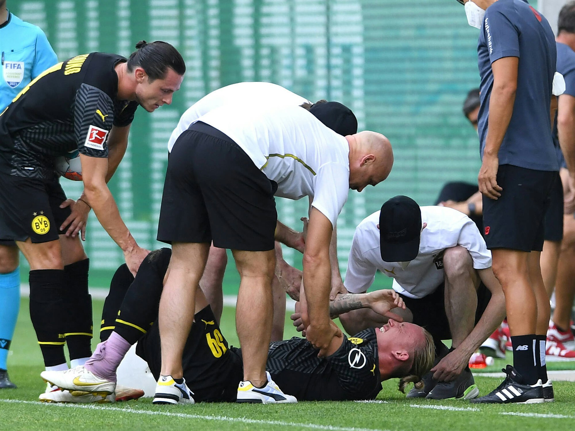 Marius Wolf liegt mit schmerzverzerrtem Gesicht auf dem Rasen.