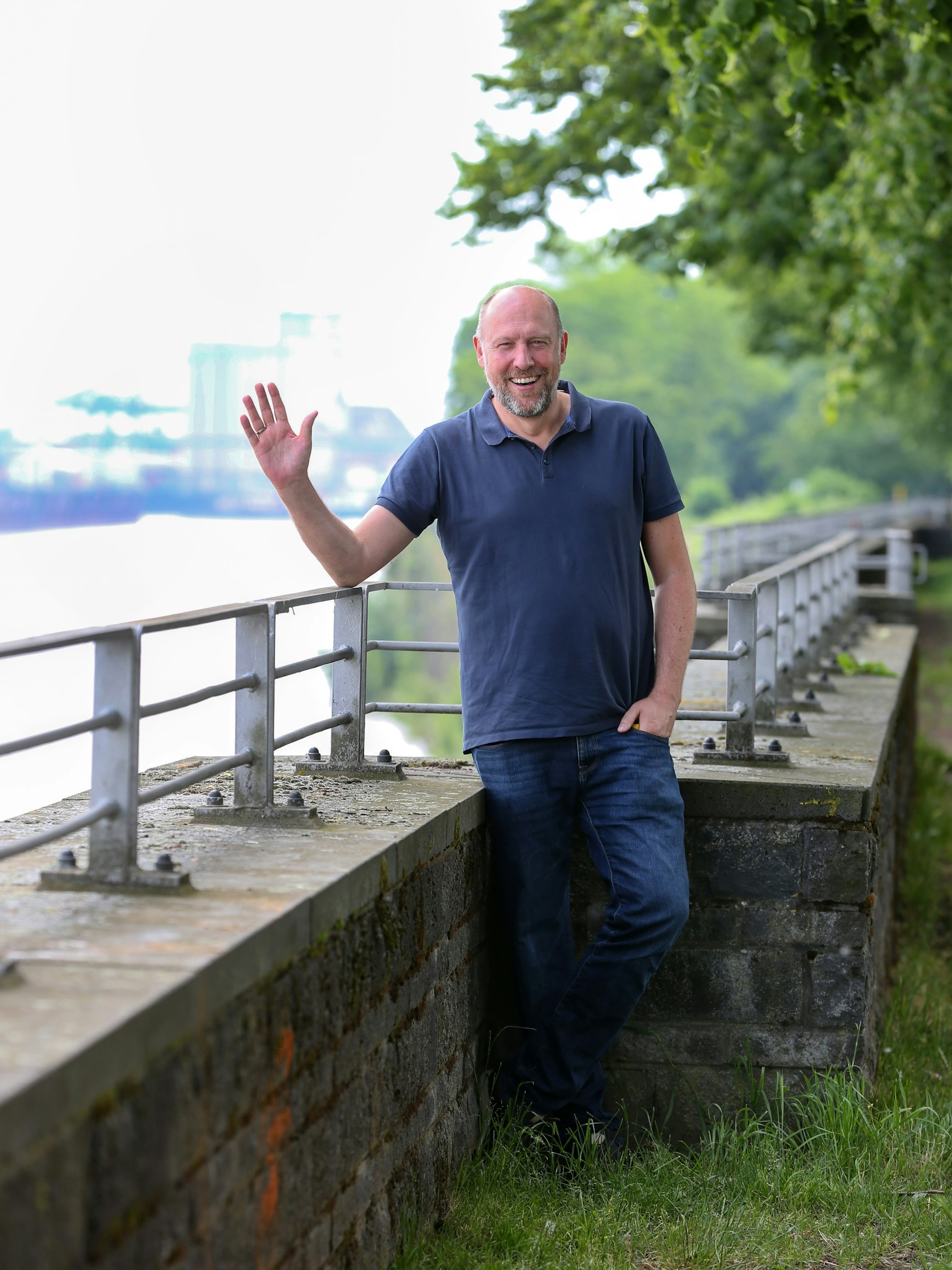 WDR-Moderator Sven Pistor winkt am Rhein in die Kamera