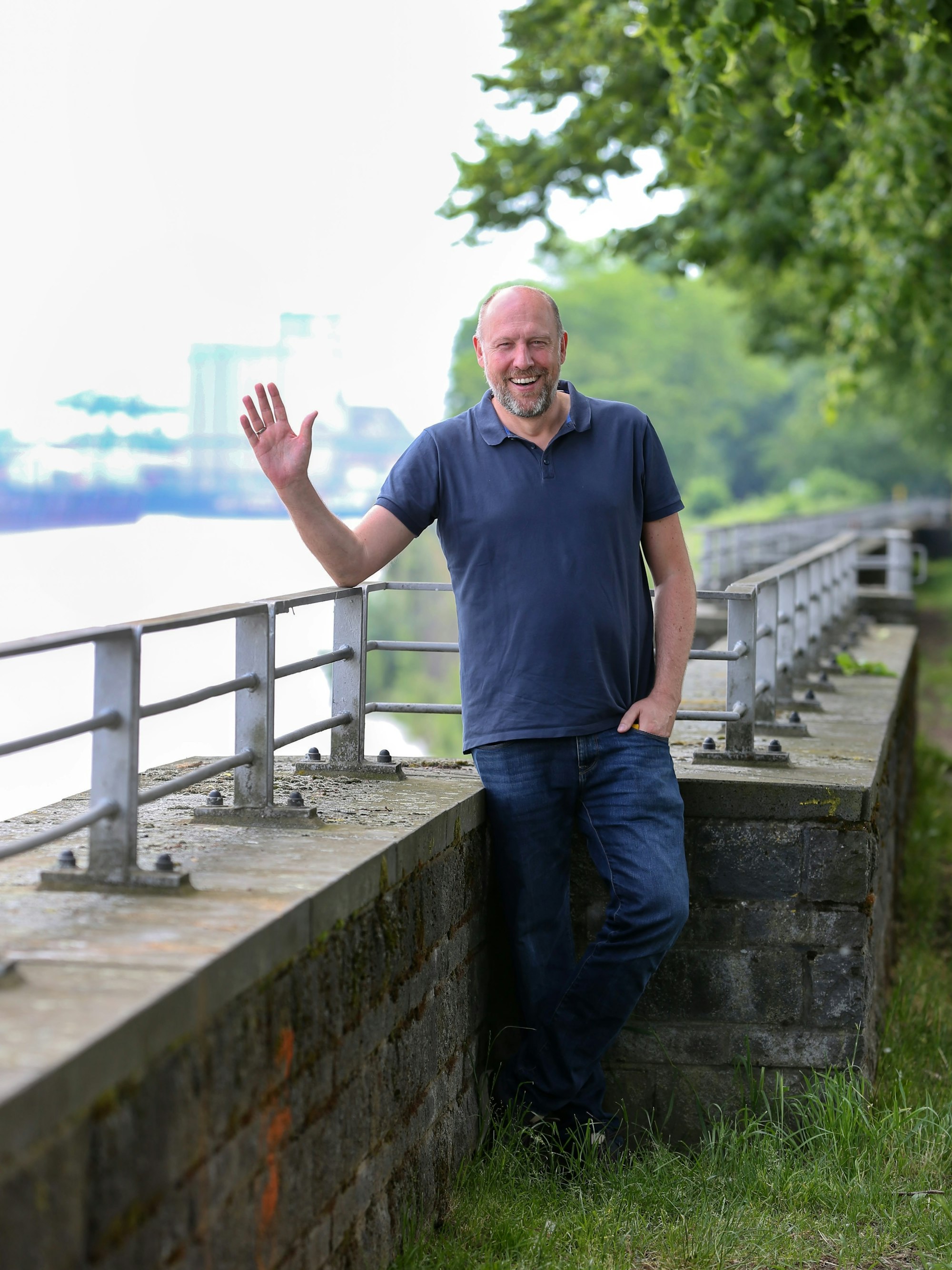 WDR-Moderator Sven Pistor winkt am Rhein in die Kamera