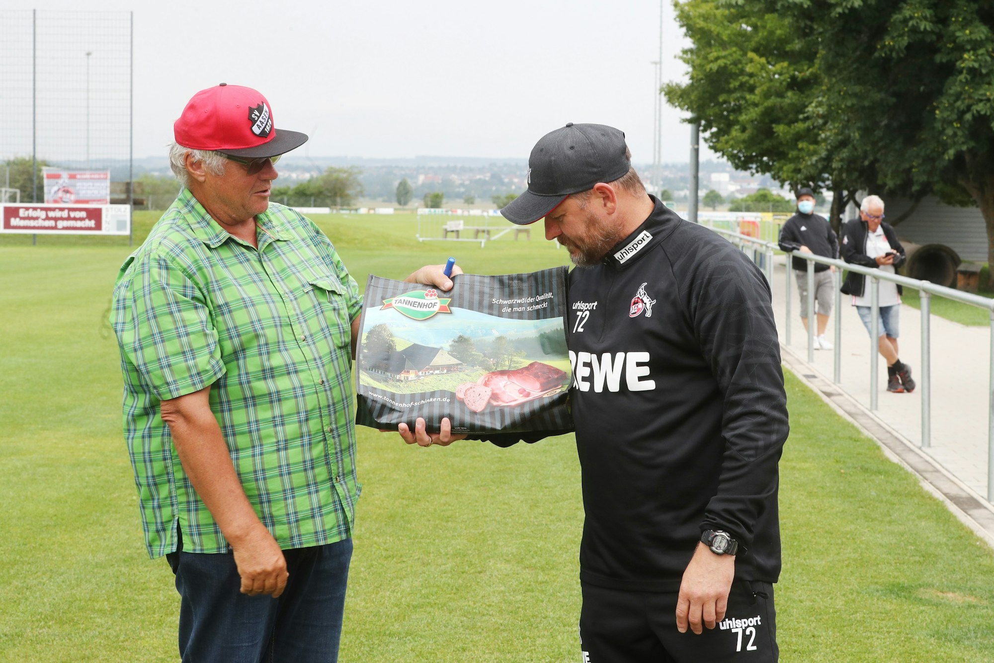 Steffen Baumgart wird im Trainingslager des 1. FC Köln mit einem Schinken überrascht.