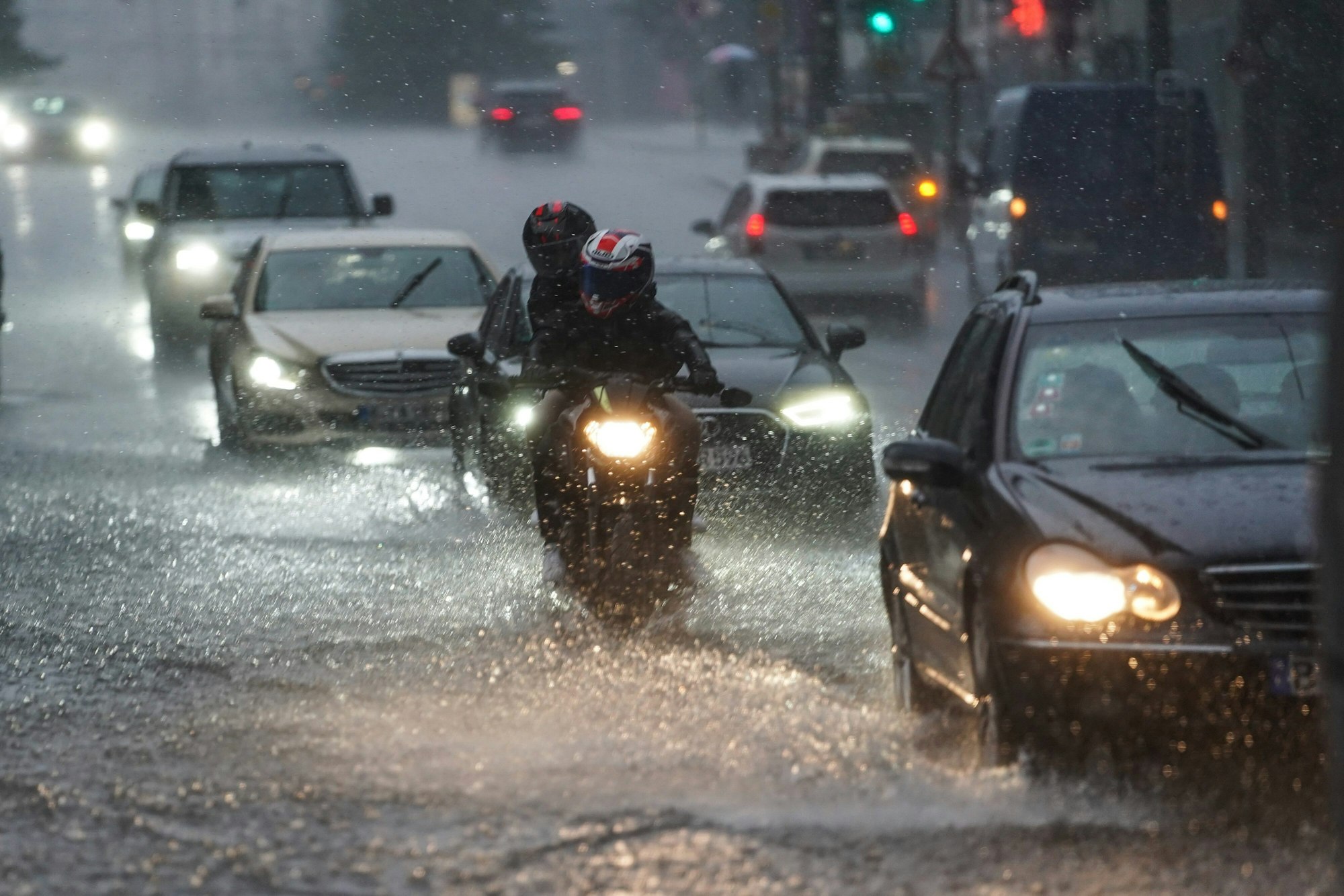 Autos und Motorräder fahren bei starkem Regen am 25.07.2021 über die überflutete Friedrichstraße in Berlin-Mitte.