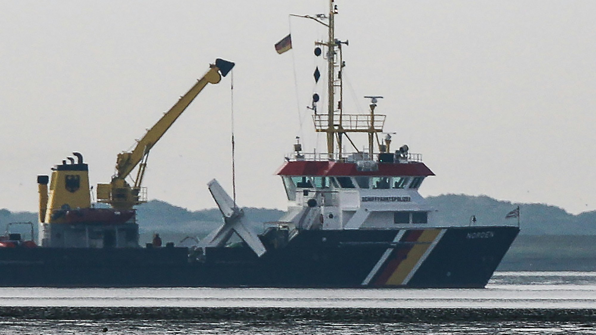 Das Wrack einer verunglückten Cessna hängt am Kran an Bord des Tonnenlegers im Wattenmeer vor Norderney. Beim Absturz des Kleinflugzeuges ist der 65 Jahre alte Pilot ums Leben gekommen.