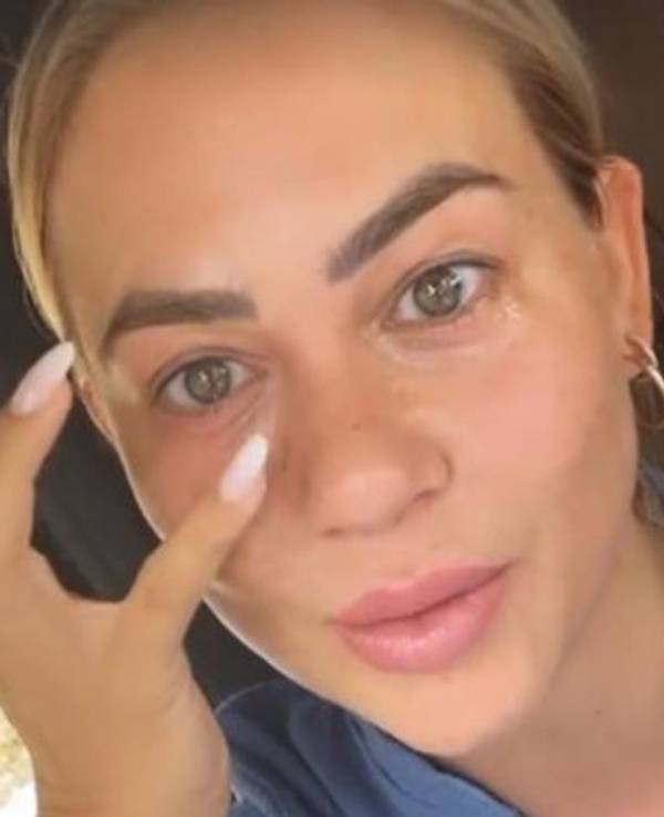 Jessica Paszka sitz im Auto und zeigt auf ihre Augenerkrankung.