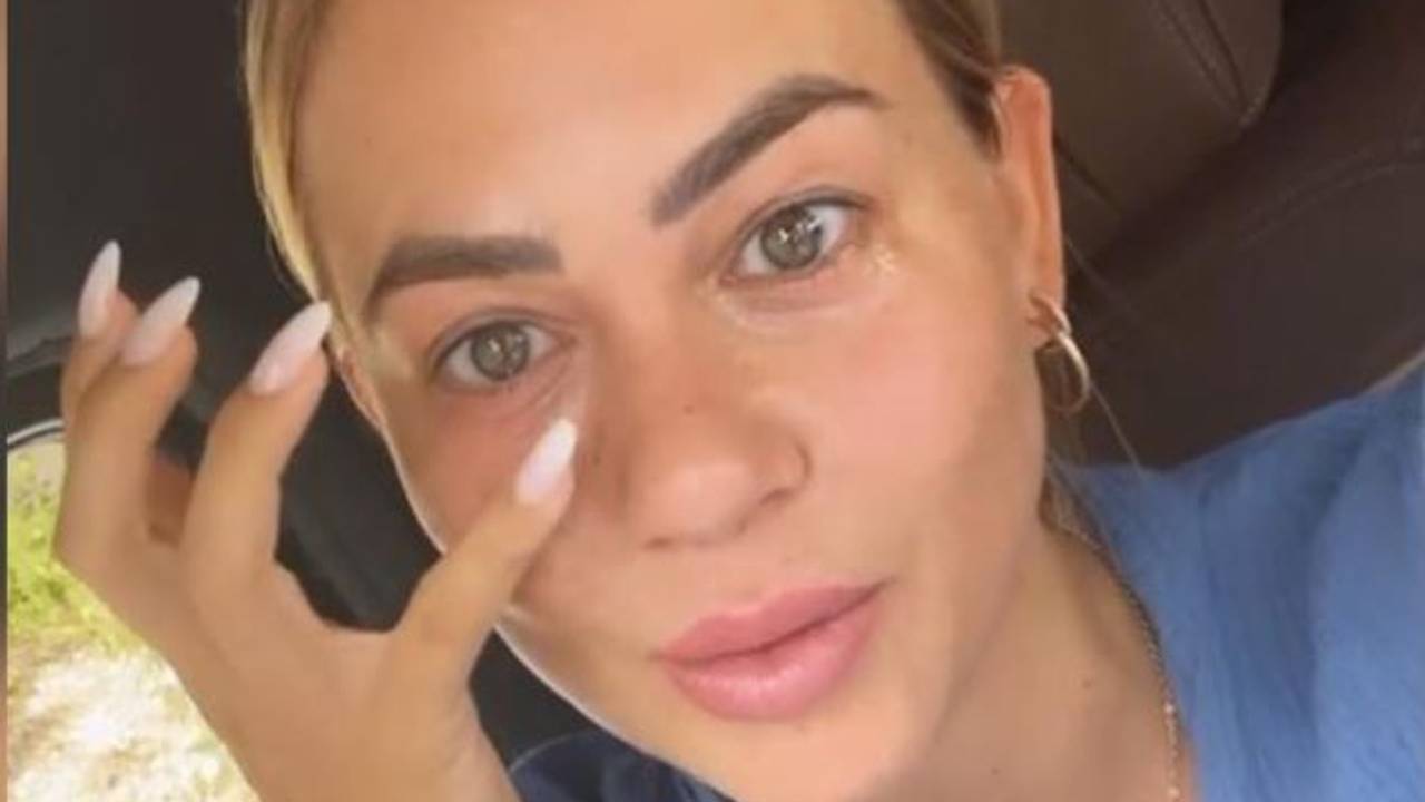 Jessica Paszka sitz im Auto und zeigt auf ihre Augenerkrankung.