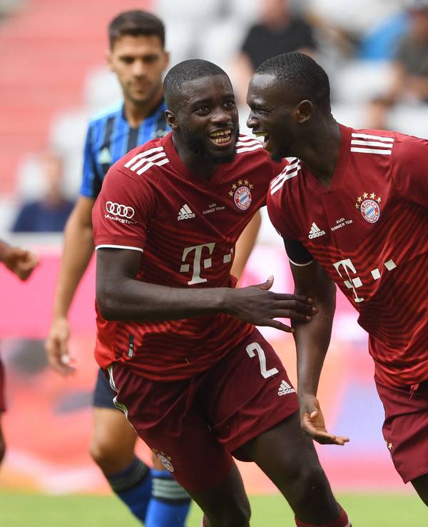 Bayern Münchens neuer Verteidiger Dayot Upamecano jubelt mit Tanguy Nianzou (r.).