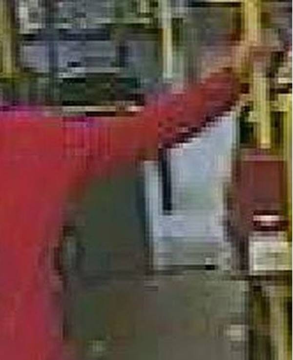 Mann in roter Jacke lehnt an Geländer in einem Bus in Köln.
