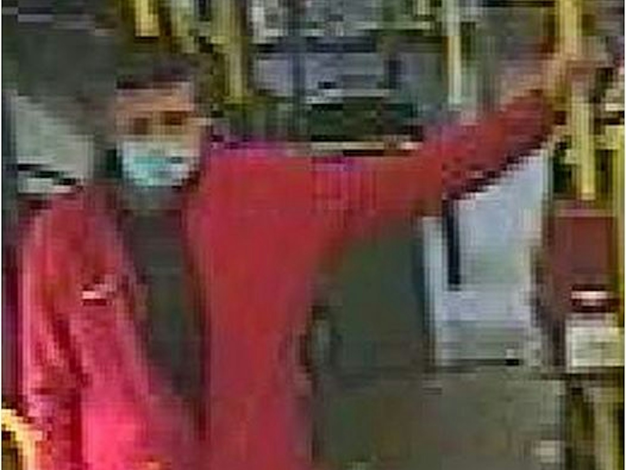 Mann in roter Jacke lehnt an Geländer in einem Bus in Köln.