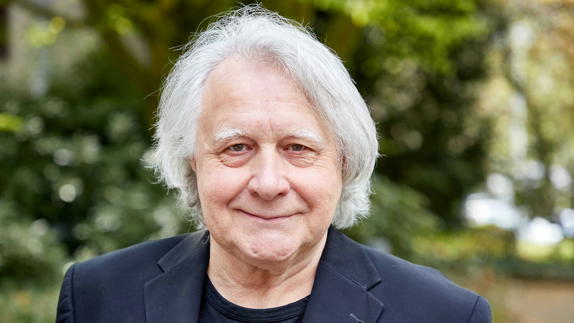 Peter Urban, langjähriger Moderator des ESC, lächelt bei einem Fototermin im April 2021 in die Kamera.