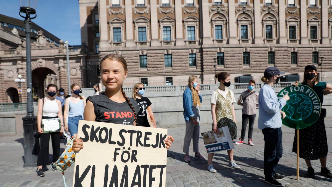 Greta Thunberg ist geimpft und hält ihr Schild mit der Aufschrift „Skolstrejk för Klimatet” in den Händen.