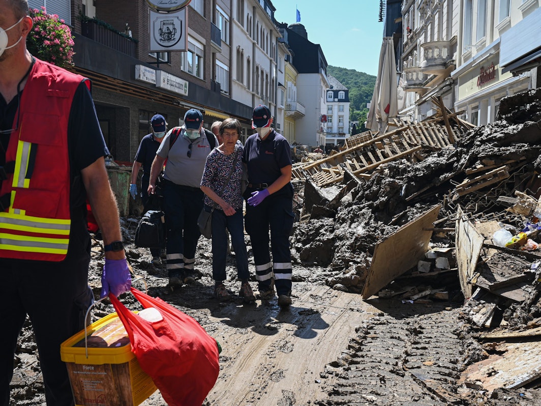 Helfer der Johanniter in Bad Neuenahr-Ahrweiler begleiten nach der Flutkatastrophe eine Seniorin aus ihrer Wohnung.