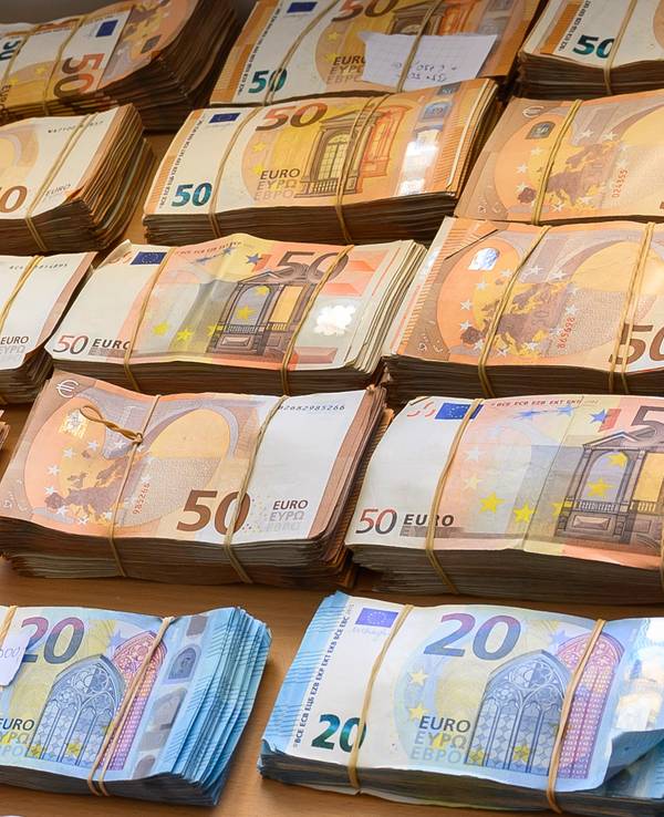 20er- und 50er-Geldbündel liegen auf einem Tisch.