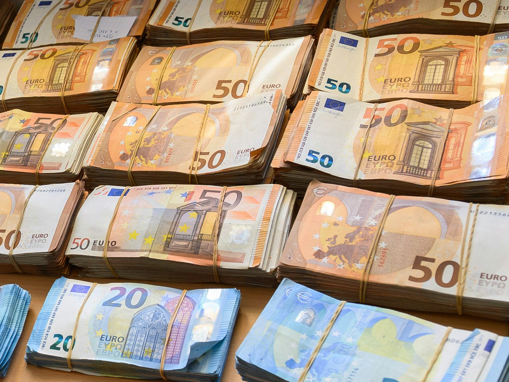 20er- und 50er-Geldbündel liegen auf einem Tisch.