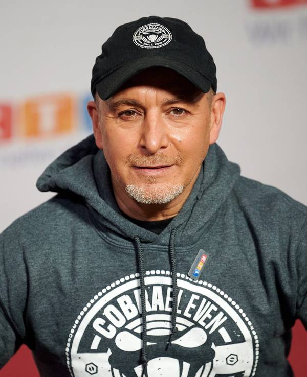 Der Schauspieler Erdogan Atalay sitzt beim 25. RTL Spendenmarathon vor einer Fotowand.