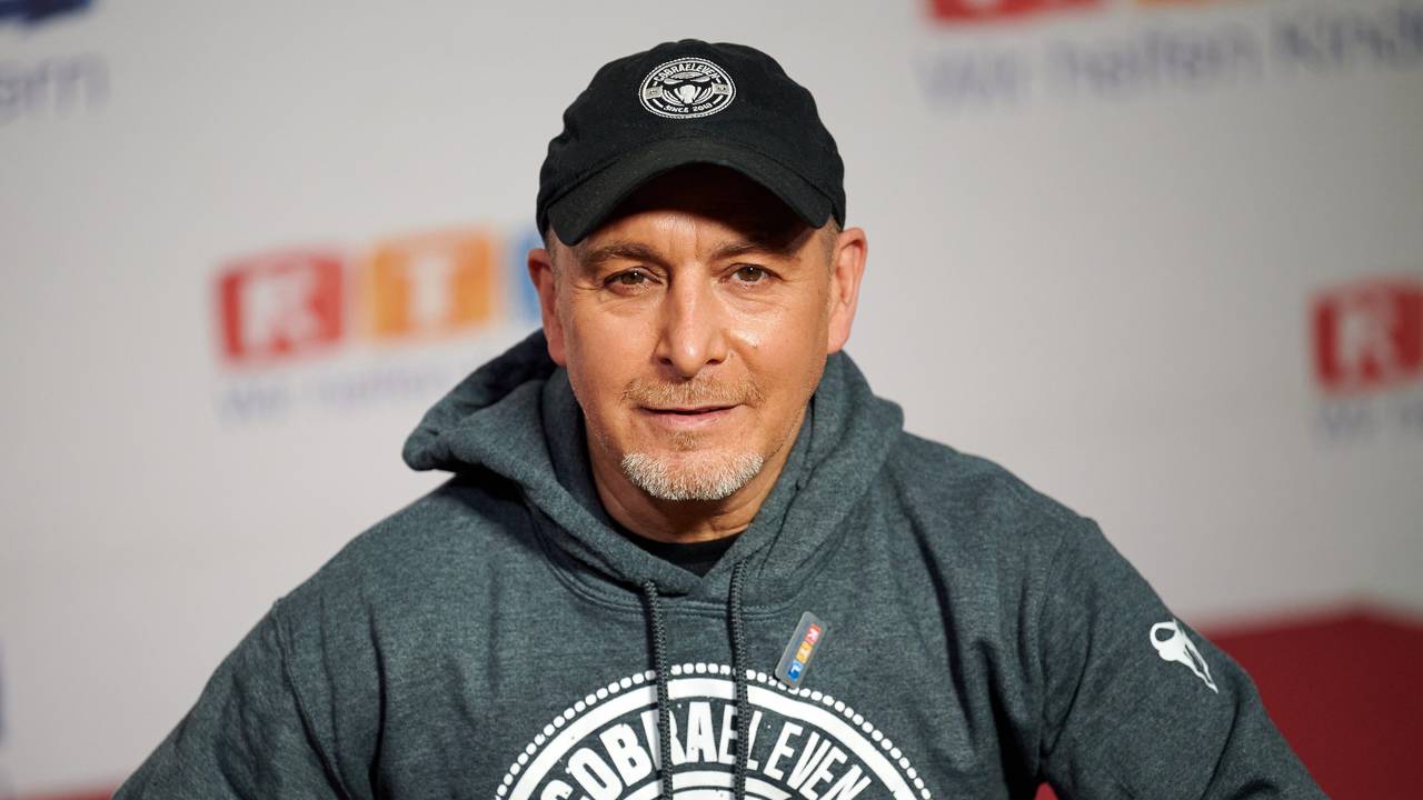 Der Schauspieler Erdogan Atalay sitzt beim 25. RTL Spendenmarathon vor einer Fotowand.