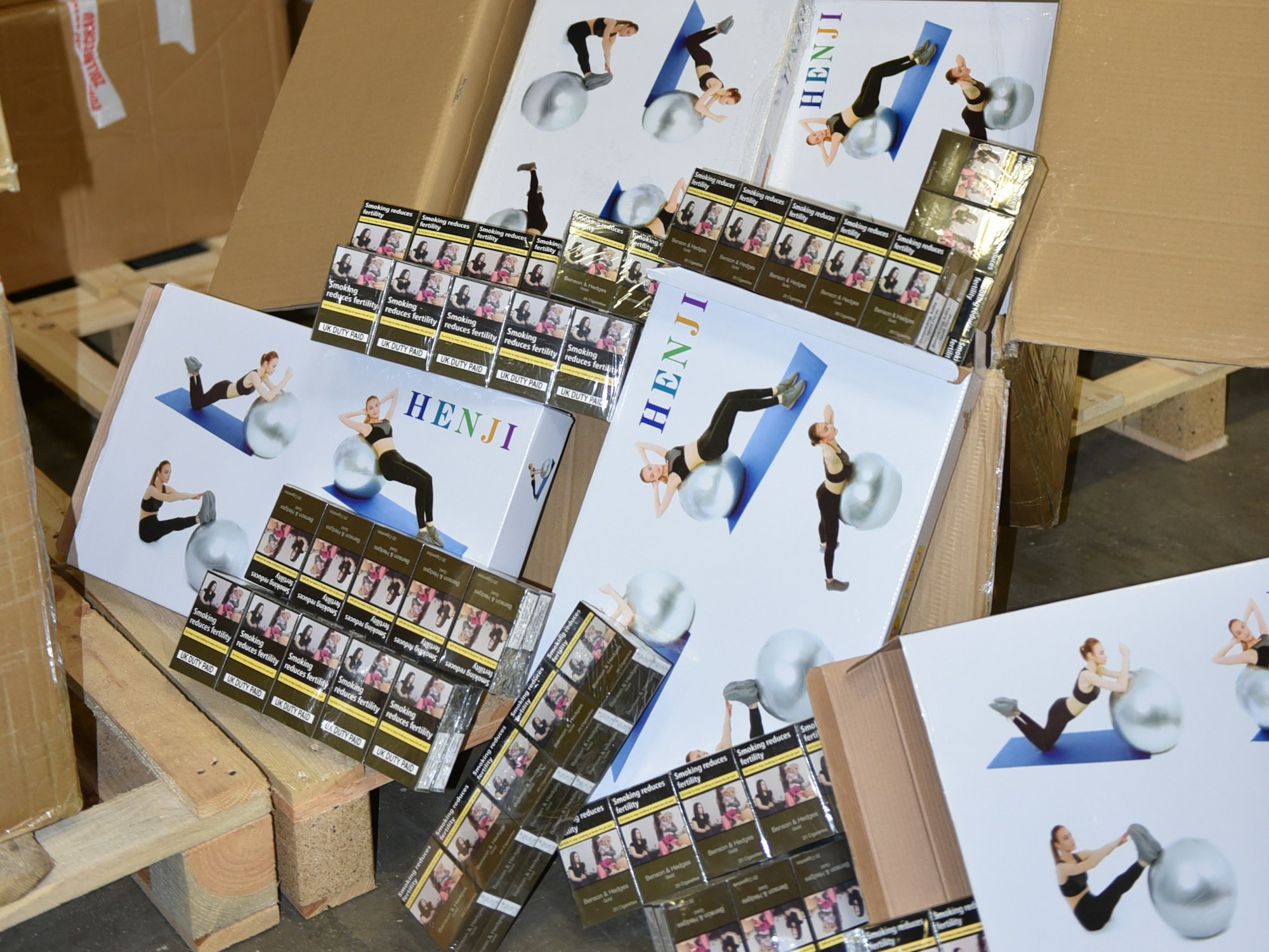 Zigarettenstangen liegen neben den Verpackungen für Gymnastikbälle.