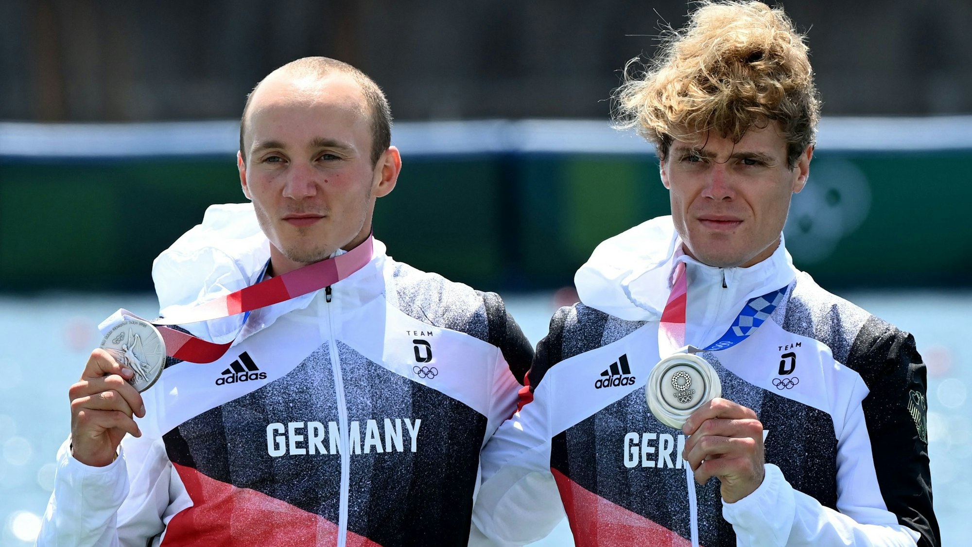 Jonathan Rommelmann und Jason Osborne zeigen ihre Silbermedaillen bei Olympia in Tokio