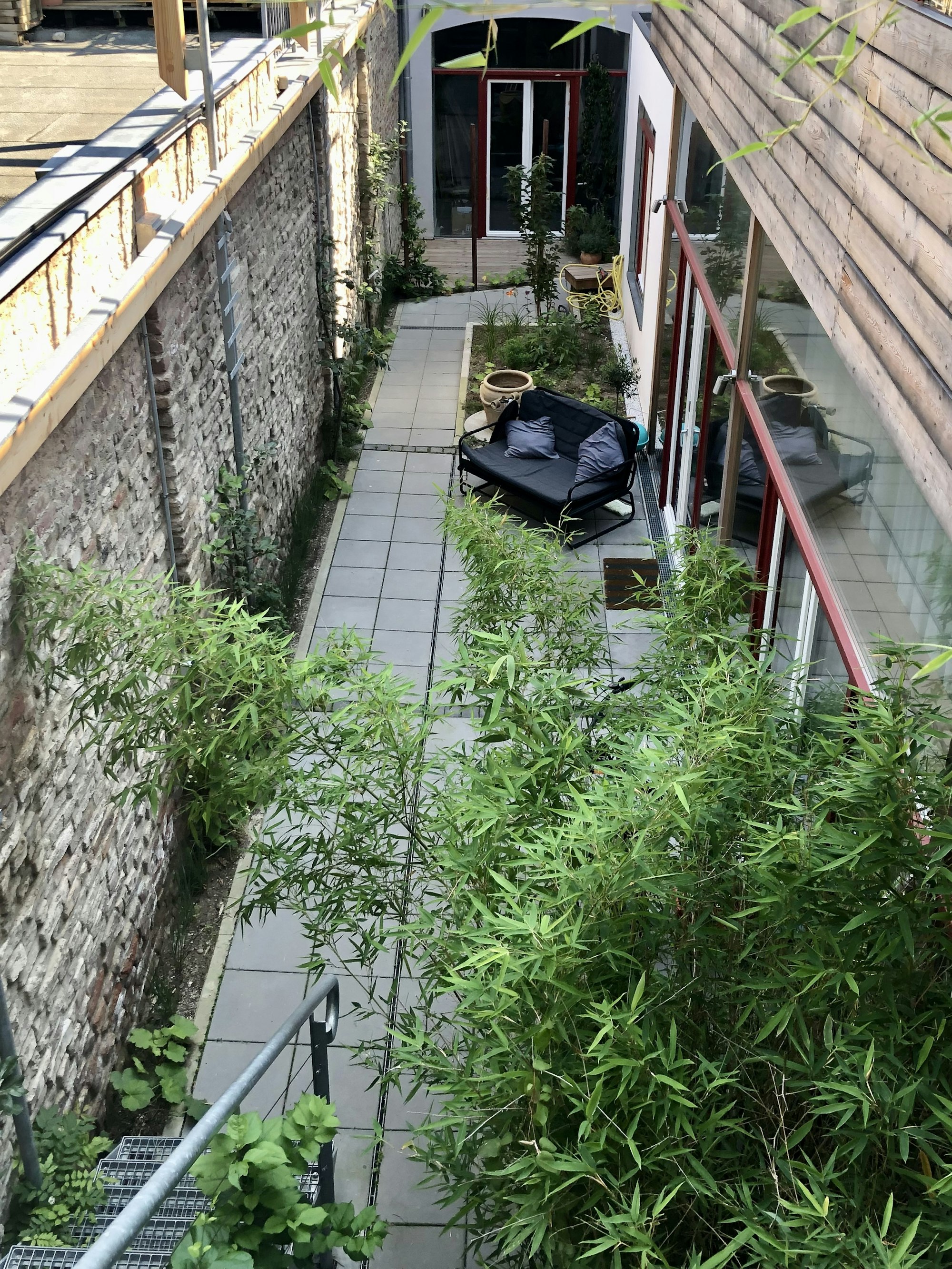 Der Weg vorbei an den Loftwohnungen im Innenhof ist bereits voll bewachsen.