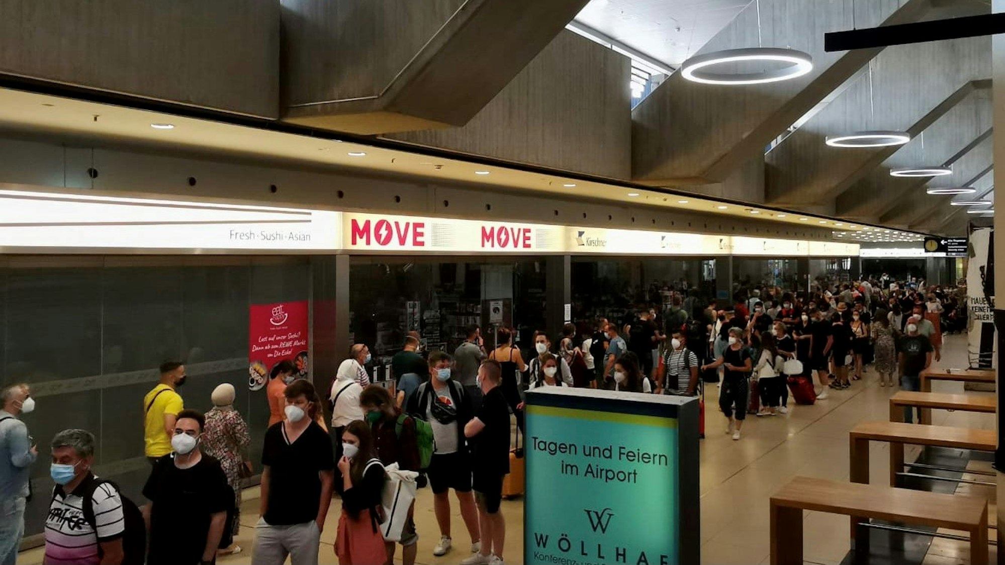 Reisende stehen am Flughafen Köln/Bonn Schlange.
