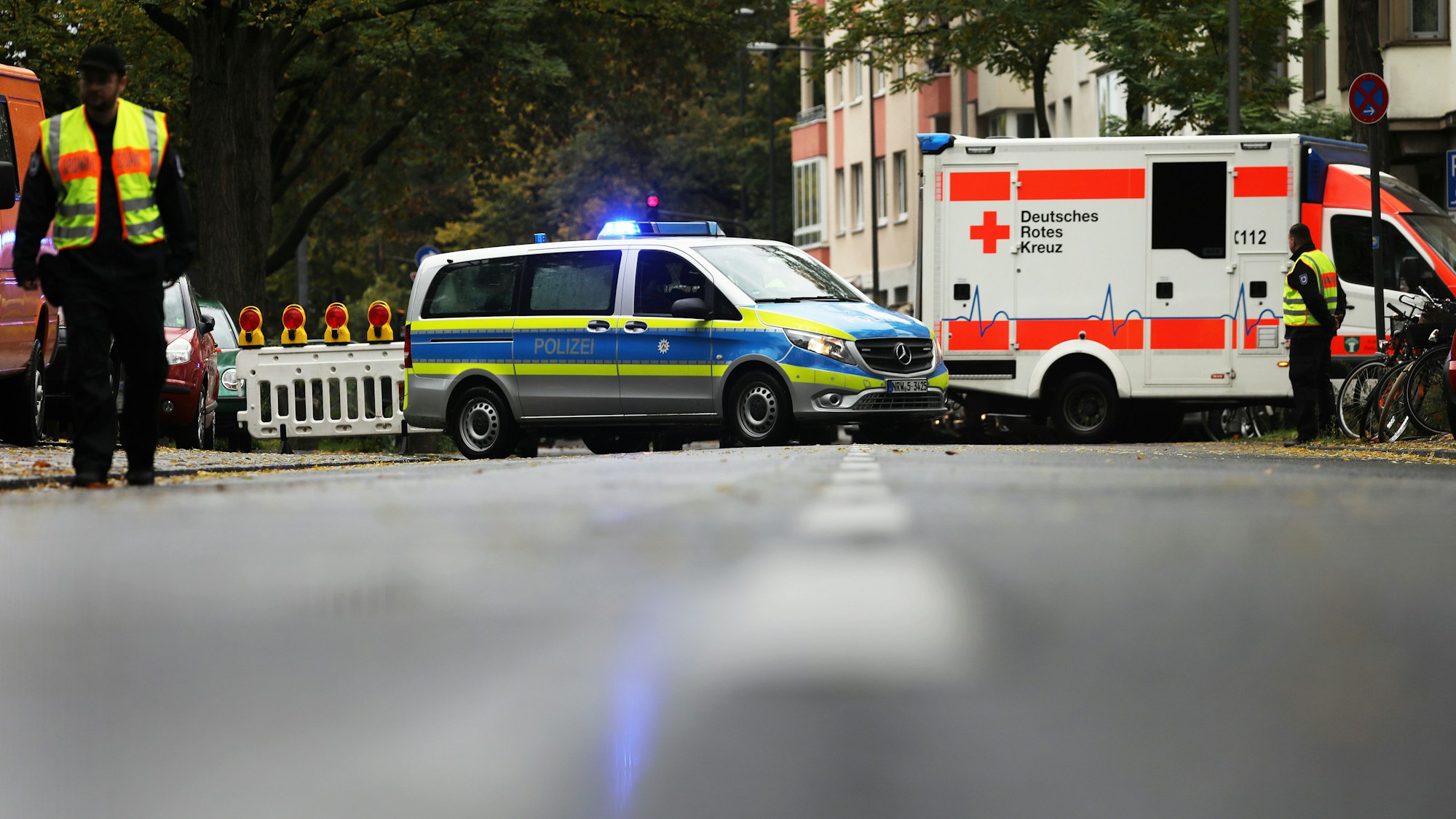 Polizisten und Mitarbeiter des Ordnungsamtes sperren eine Straße.