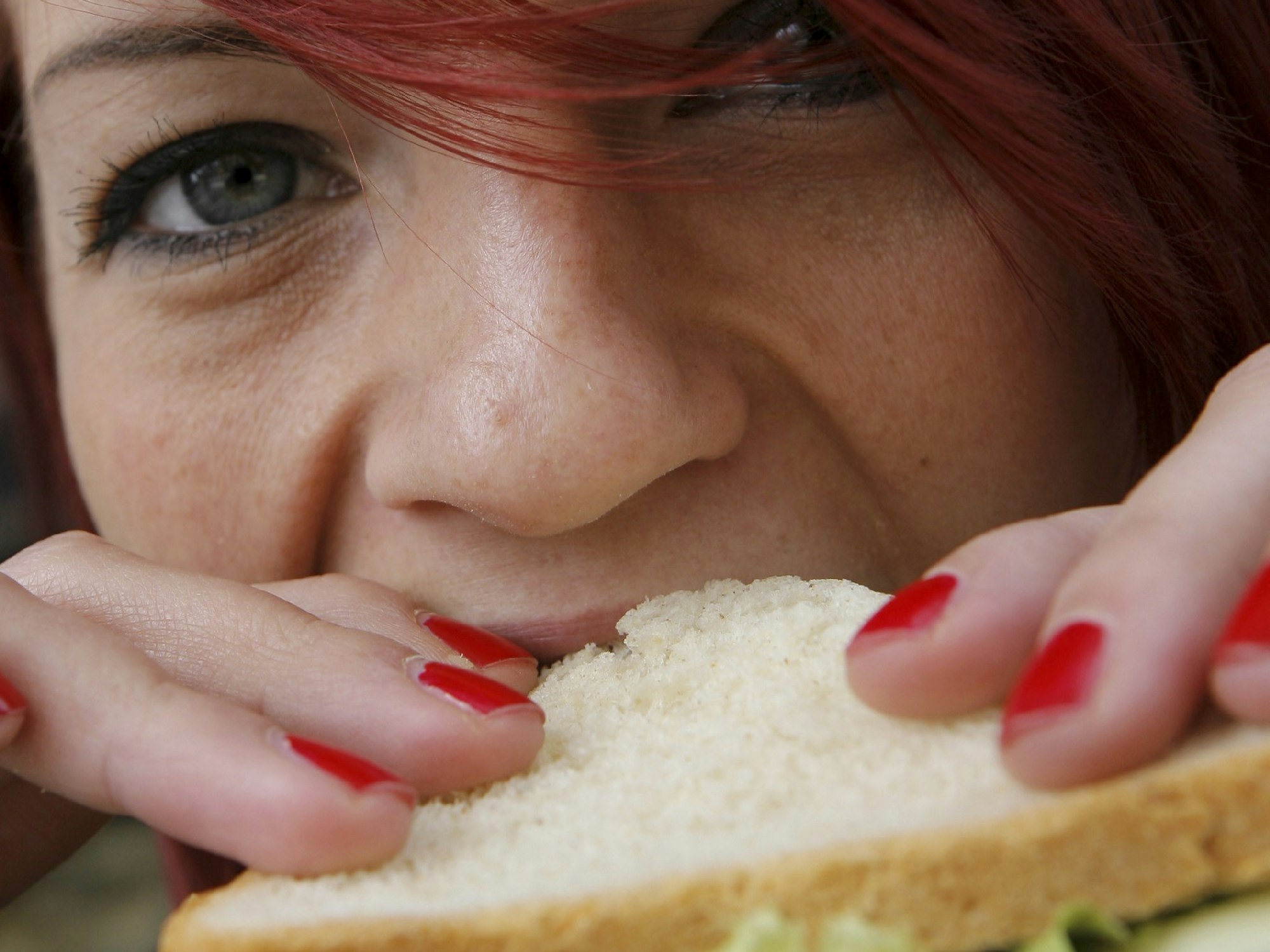 Eine Frau beißt am 28.03.2008 in Berlin in ein Käse-Sandwich.