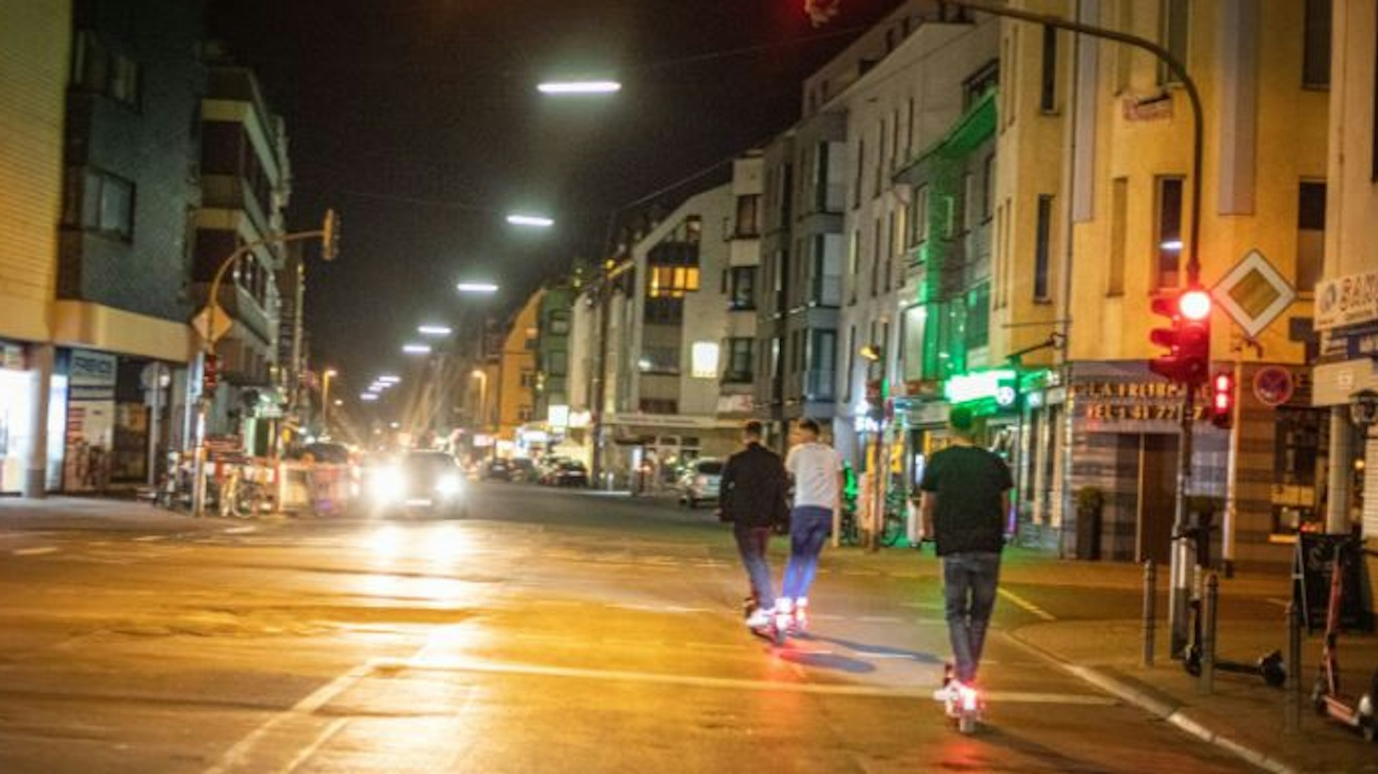 Männer fahren mit E-Scootern über die Berrenrather Straße in Sülz.