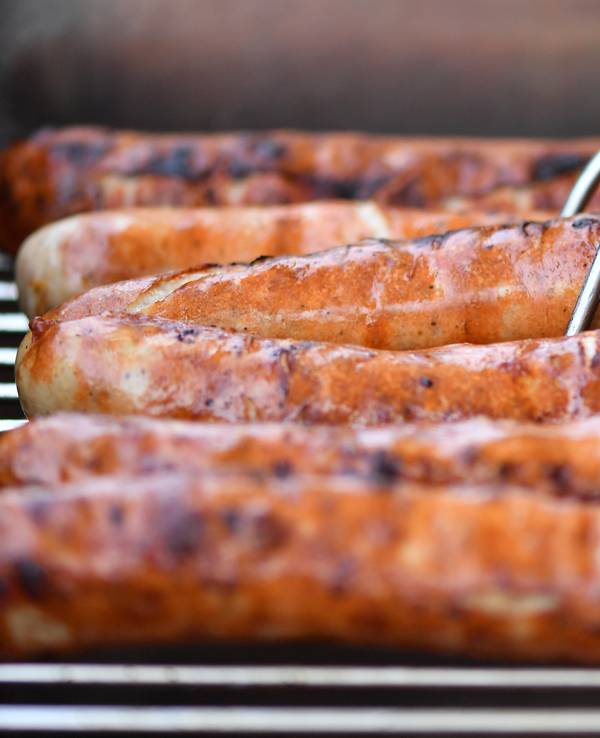 Auf einem Grill liegen sechs braun gebrutzelte Thüringer Bratwürste nebeneinander.