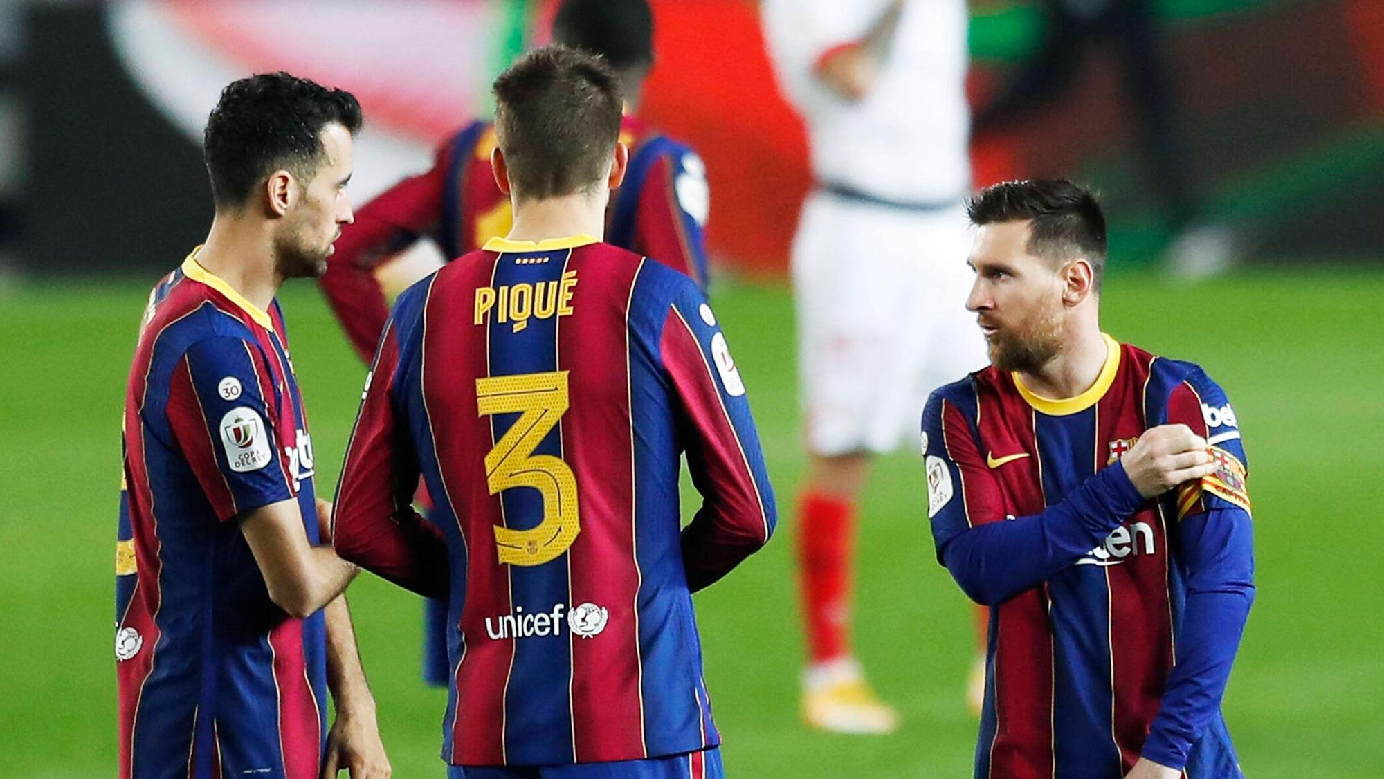 Sergio Busquets und Gerard Pique reden bei einem Spiel des FC Barcelona mit Lionel Messi.