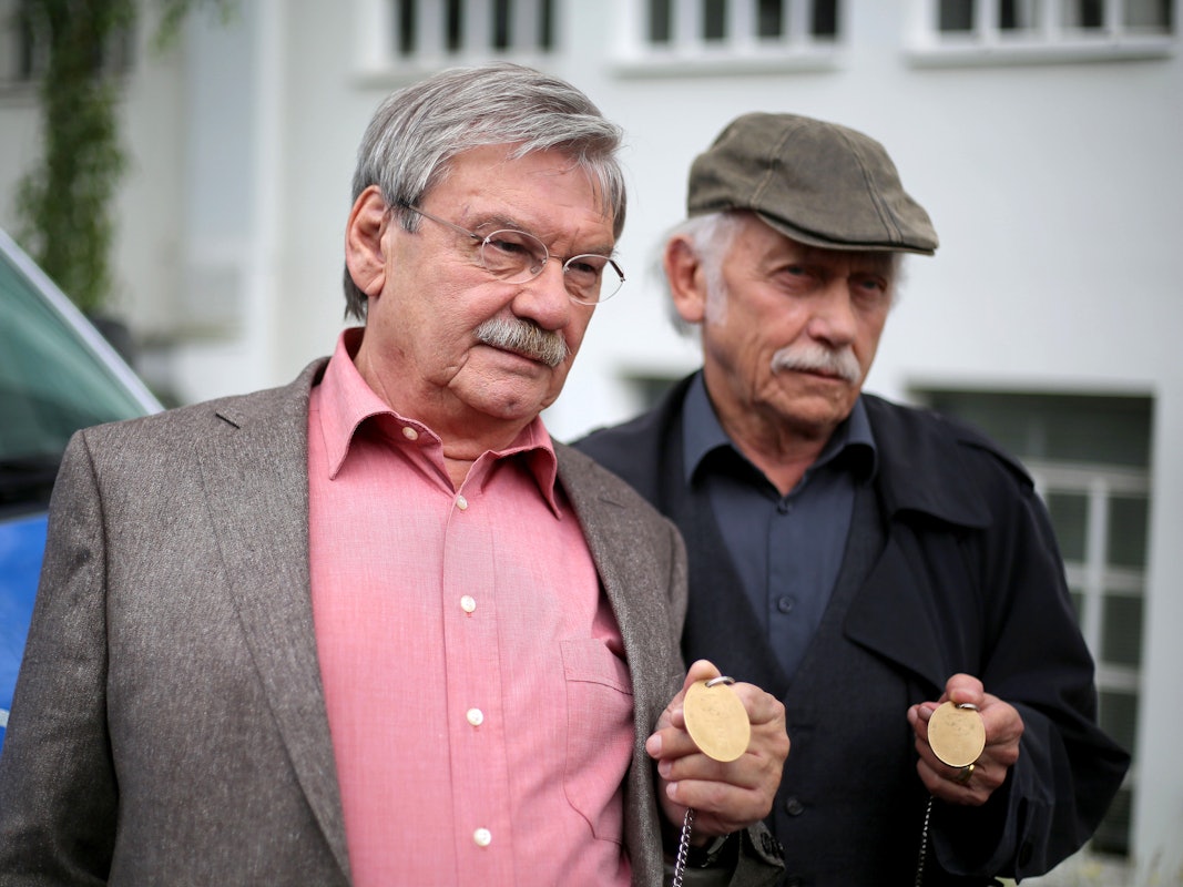 Die Schauspieler der ARD-Vorabendserie "Rentnercops" Tilo Prückner (r) als Kommissar Edwin Bremer und Wolfgang Winkler als Kommissar Günter Hoffmann stehen am 30.06.2016 in Köln (Nordrhein-Westfalen) in einer Drehpause an einem Polizeifahrzeug am Set.