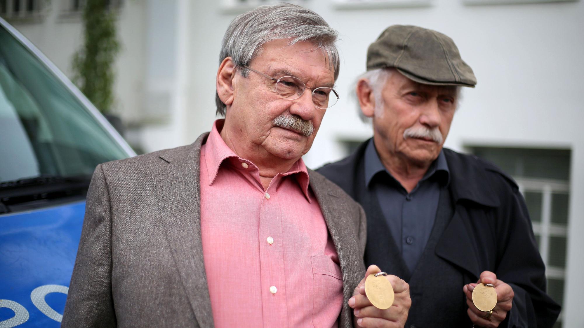 Die Schauspieler der ARD-Vorabendserie "Rentnercops" Tilo Prückner (r) als Kommissar Edwin Bremer und Wolfgang Winkler als Kommissar Günter Hoffmann stehen am 30.06.2016 in Köln (Nordrhein-Westfalen) in einer Drehpause an einem Polizeifahrzeug am Set.