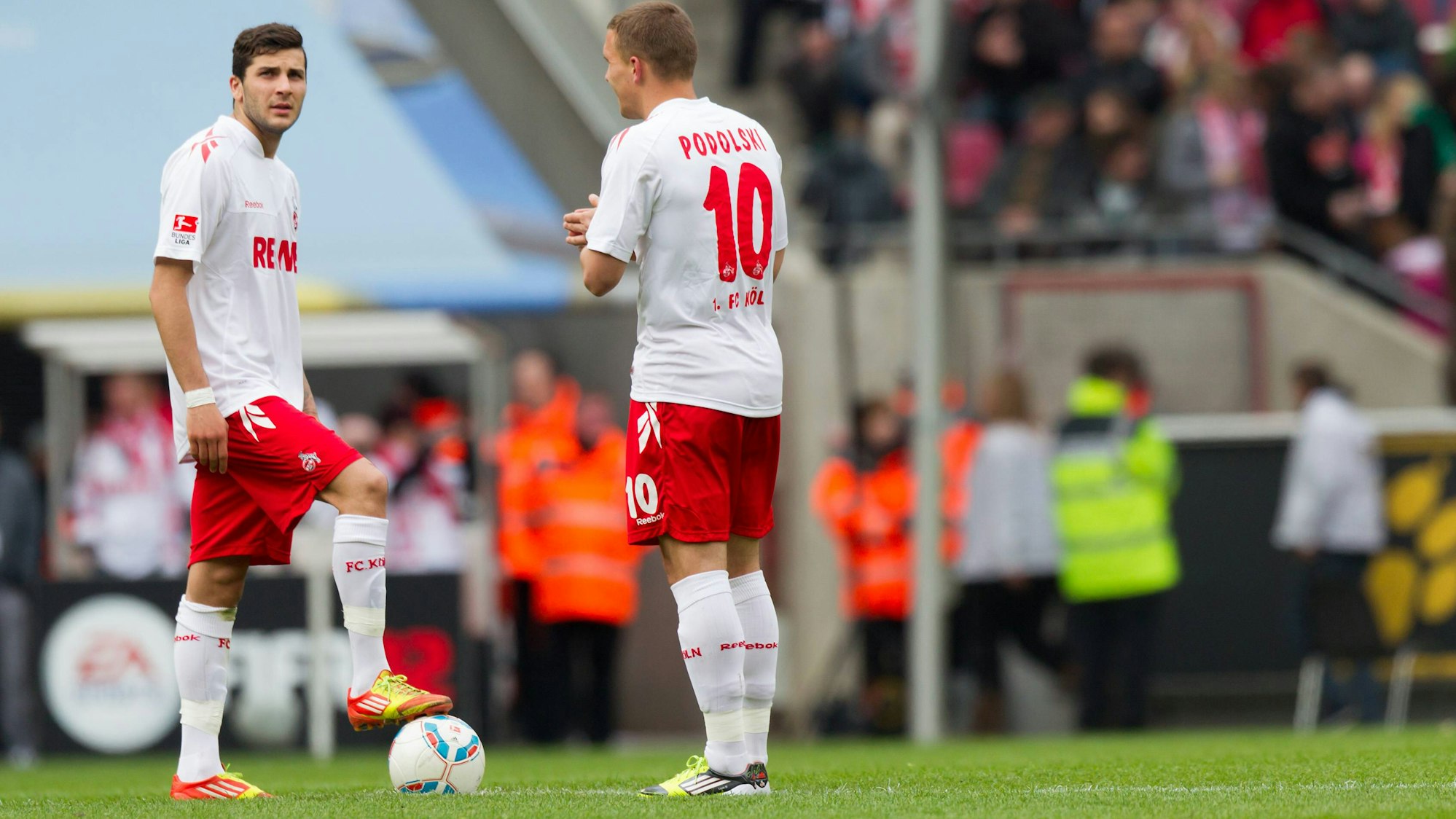 Lukas Podolski und Mikael Ishak stehen gemeinsam am Anstoßkreis.