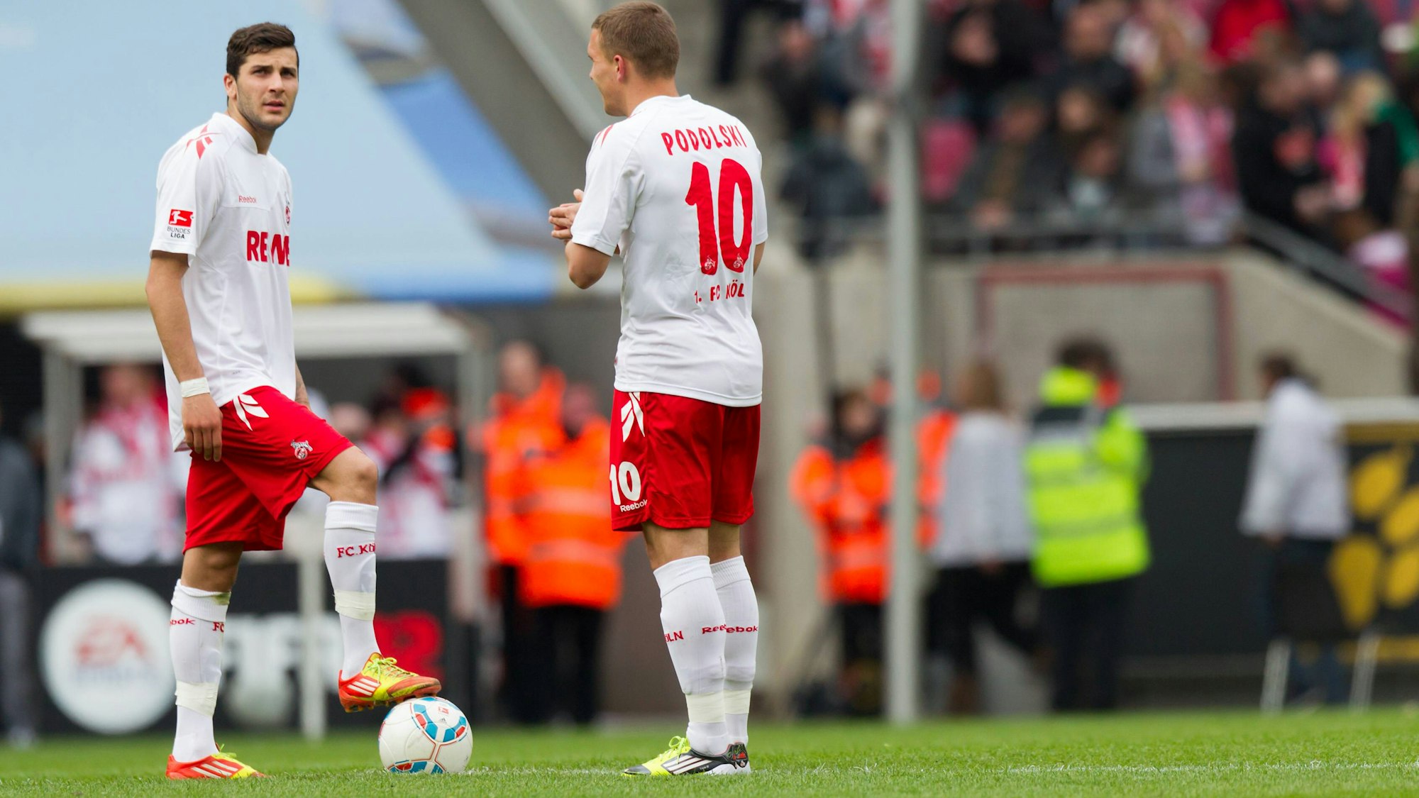 Lukas Podolski und Mikael Ishak stehen gemeinsam am Anstoßkreis.