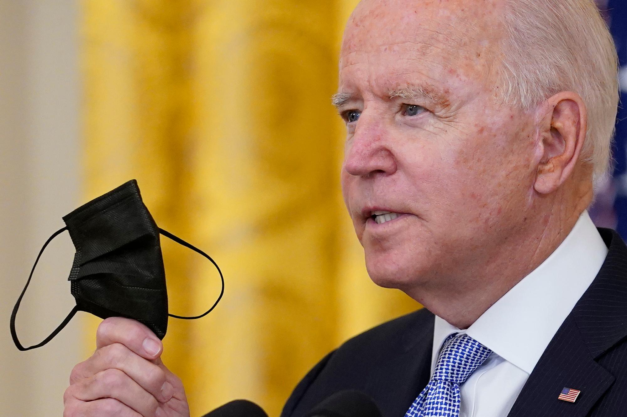 Joe Biden, Präsident der USA (hier am 29. Juli 2021) hält seinen Mund-Nasen-Schutz während er im Weißen Haus in Washington über die Impfvorschriften für Bundesbedienstete spricht.