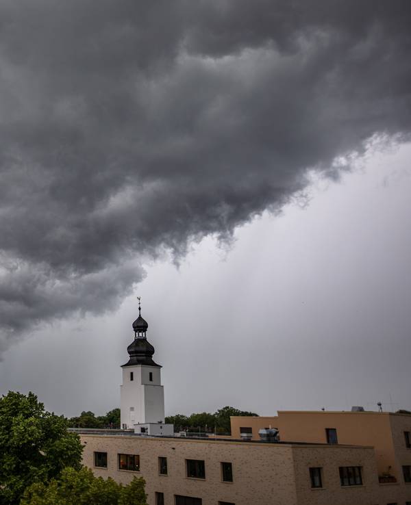 04.07.2021, Köln: Dunkle Wolken ziehen kurz vor einem Gewitter mit Starkregen über den Ortsteil Sülz. Der Kirchturm rechts gehört zur Kirche „Zur heiligen Familie“. Im Rheinland kommt es zu Unwettern. Foto: Matthias Heinekamp