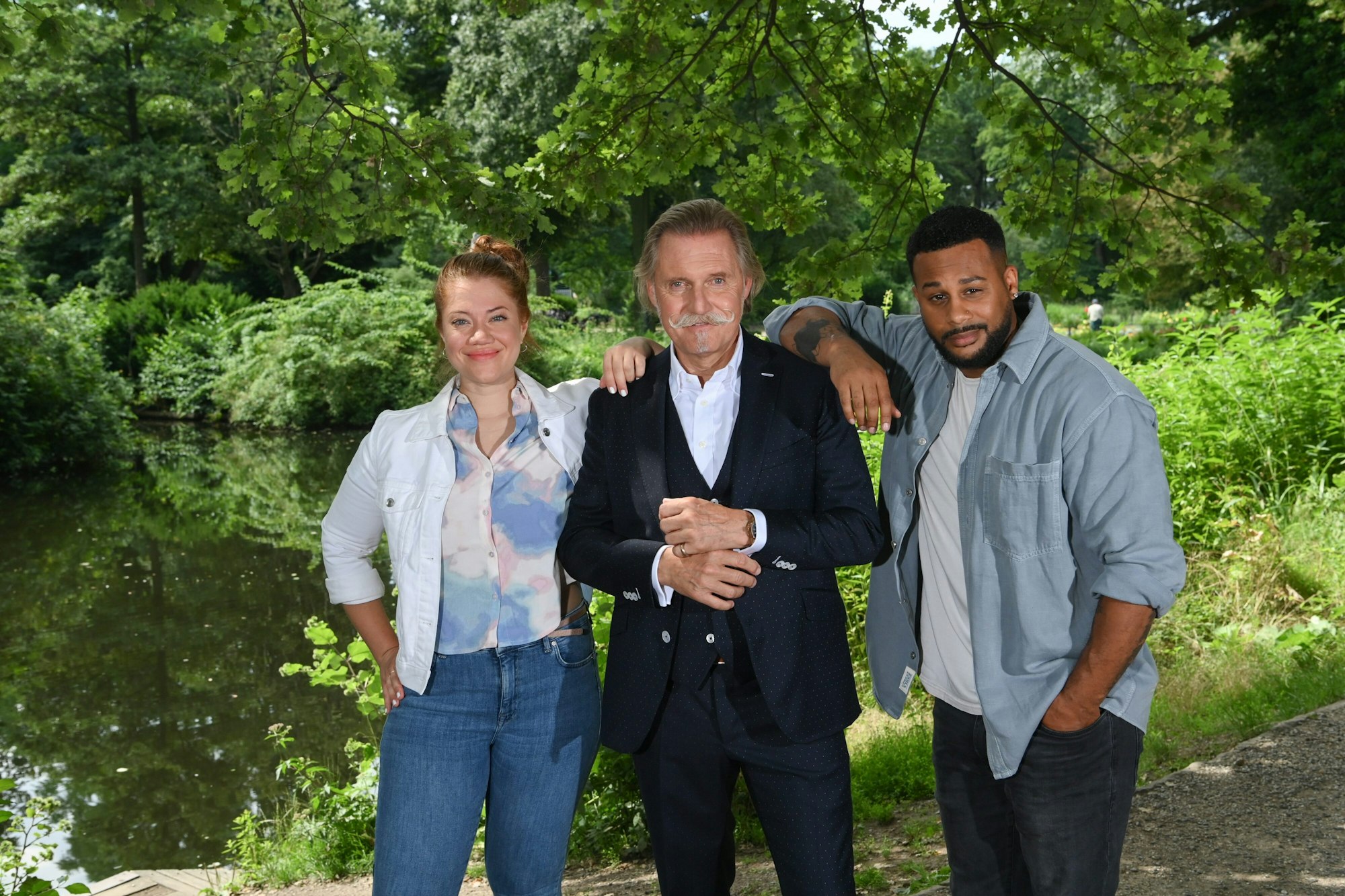 Kultanwalt Ingo Lenßen (M), Jessica Mechergui als Sarah Grüner und Marvin Ahmed-Johnson als Ben Handke stehen am Rande von Dreharbeiten zur Sat.1-Serie «Lenßen übernimmt» im Tiergarten.