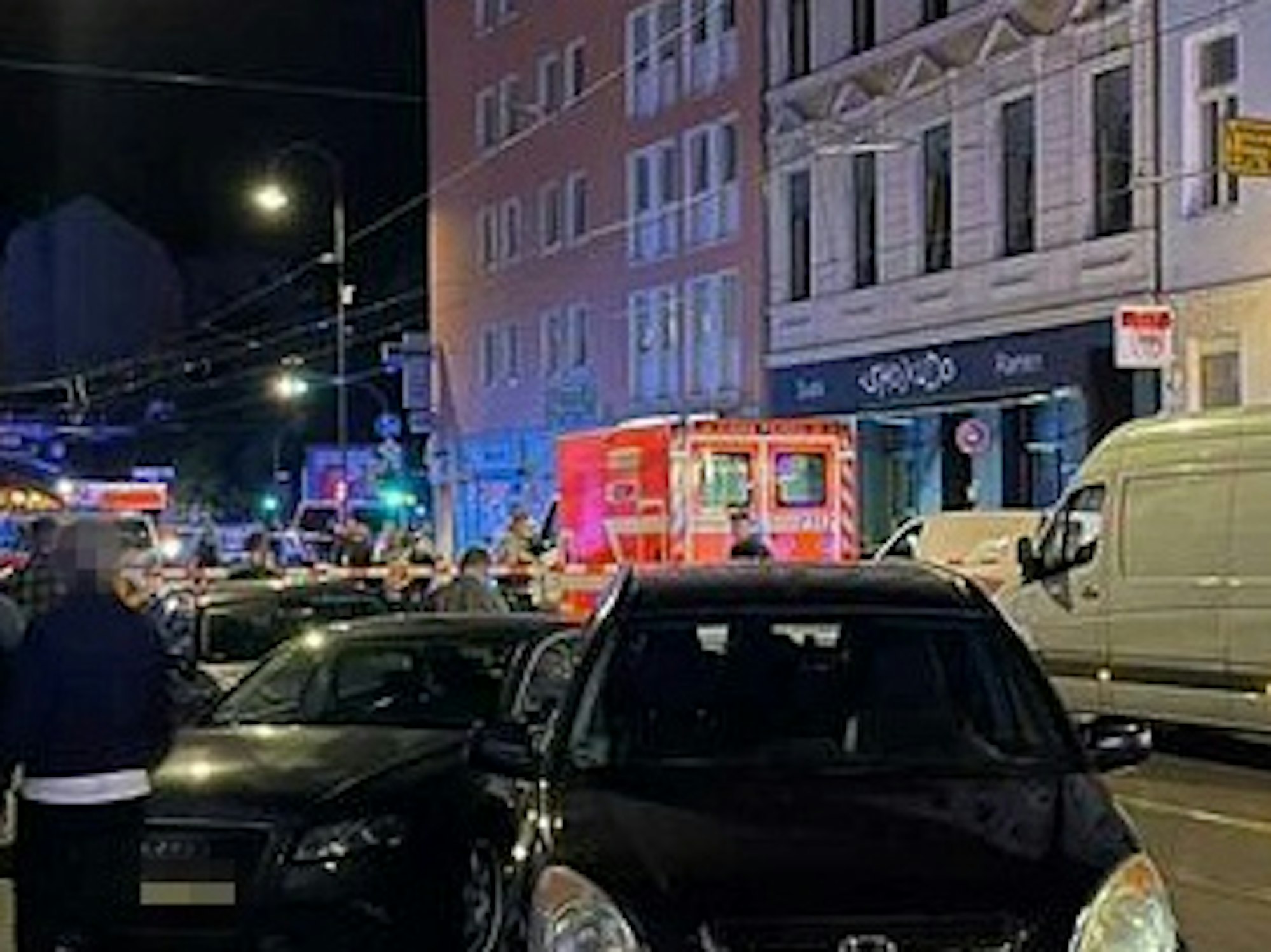 Ein Rettungswagen steht auf der Zülpicher Straße, die rund um den Tatort abgesperrt ist.