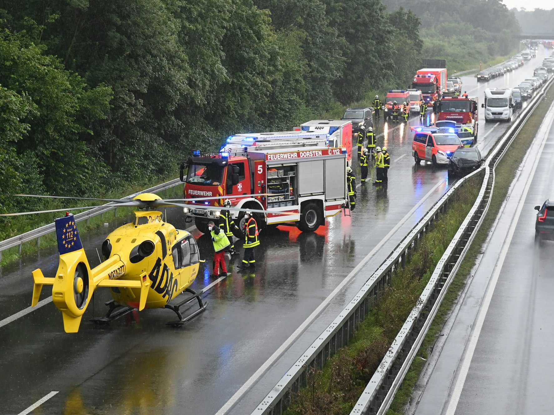 Einsatzkräfte der Feuerwegr und ein Hubschrauber des ADAC stehen auf der A31, wo sich zwei Unfälle ereignet haben.