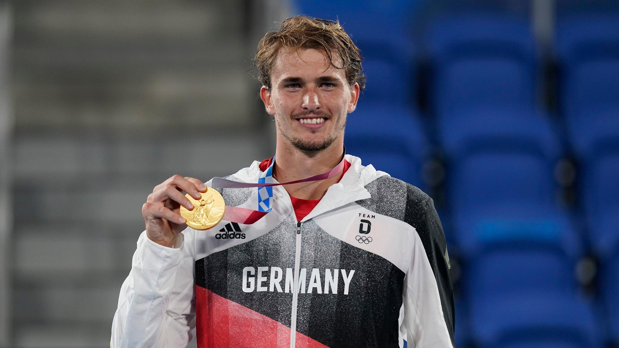 Alexander Zverev hält seine Tennis-Goldmedaille bei der Olympia-Siegerehrung in die Kamera.