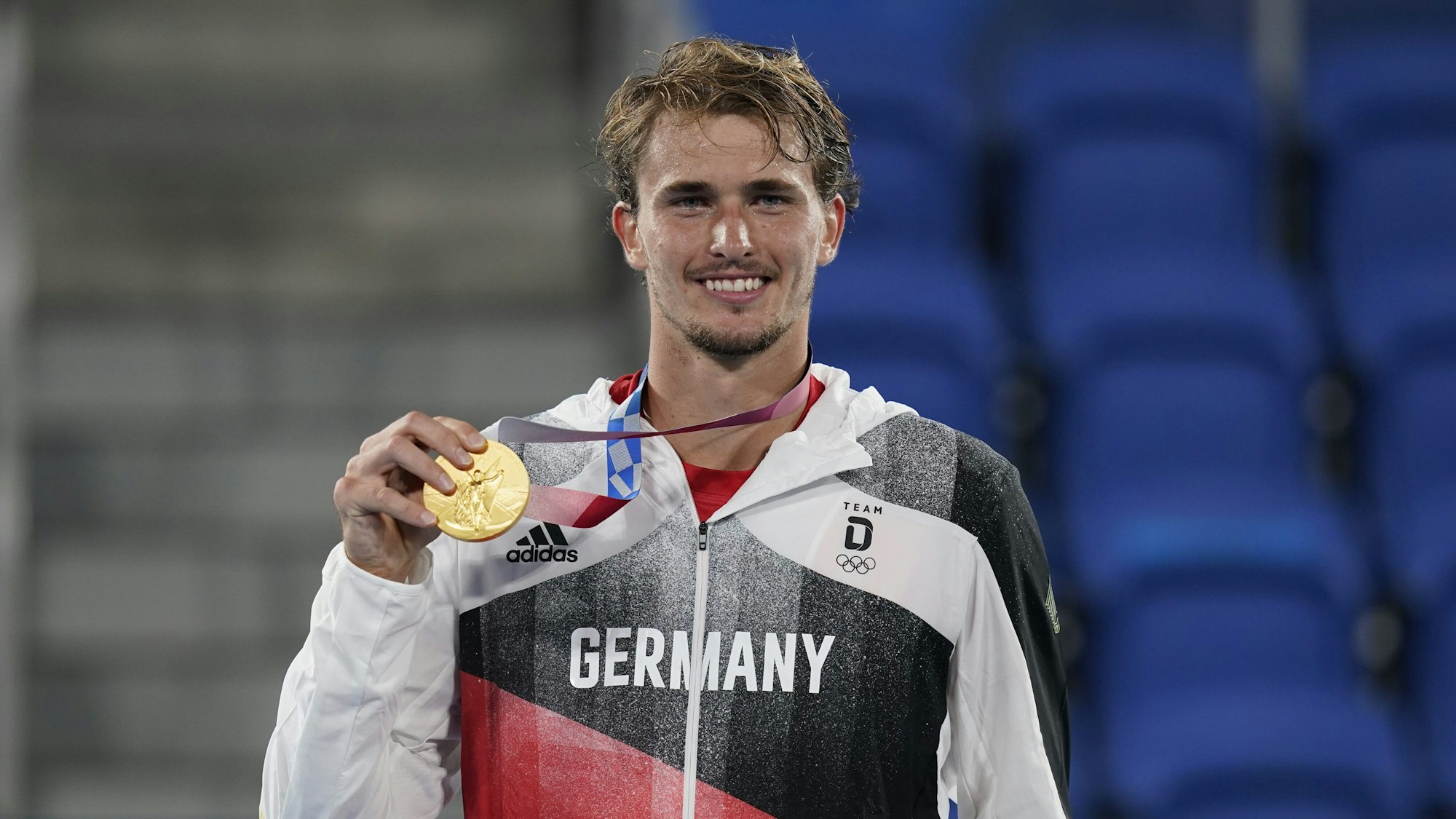 Alexander Zverev hält seine Tennis-Goldmedaille bei der Olympia-Siegerehrung in die Kamera.