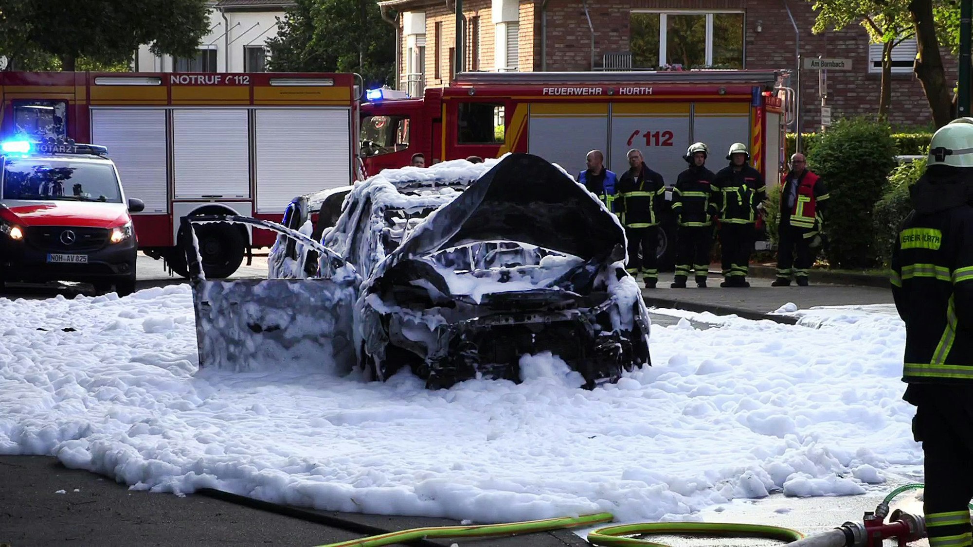 Hürth: Vom Löschschaum bedeckt steht ein Auto nach einer Explosion auf der Straße. Nach Polizeiangaben wurden dabei zwei Menschen verletzt, einer davon erlag später seinen schweren Verletzungen. In dem Wagen habe es aus noch ungeklärter Ursache eine Detonation gegeben