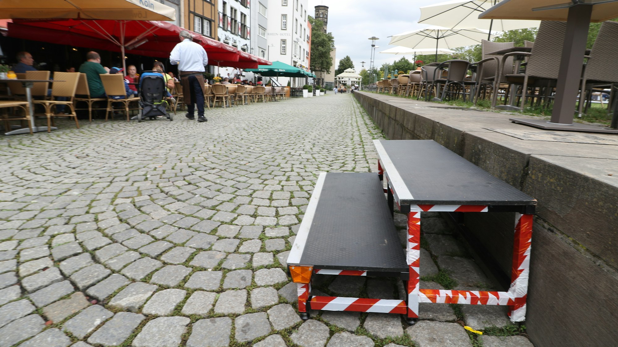 Gastronomen am Rheingarten in Köln stellen diese Treppen auf, damit Kunden besser auf die Außengastronomie gelangen können.
