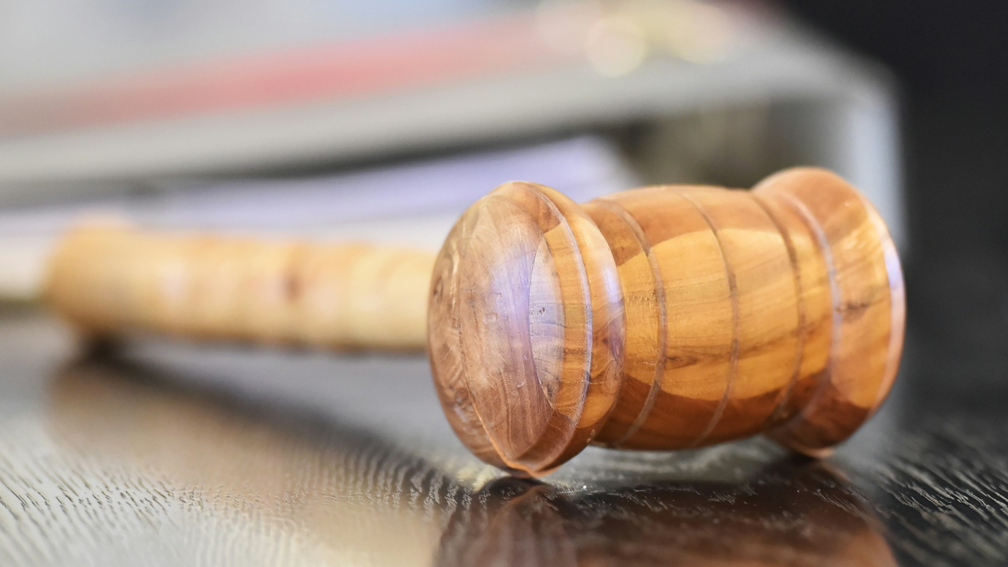 Ein Richterhammer aus Holz liegt auf der Richterbank.