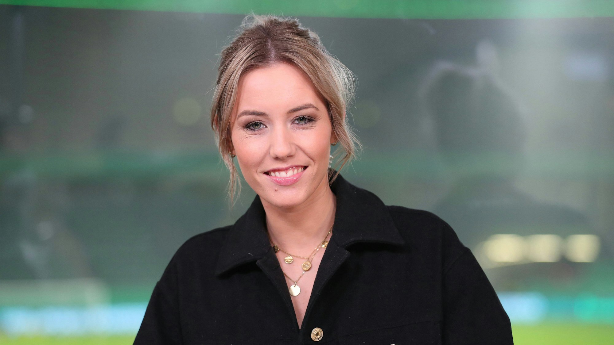 Laura Papendick lacht bei einer TV-Übertragung beim DFB-Pokal in die Kamera.