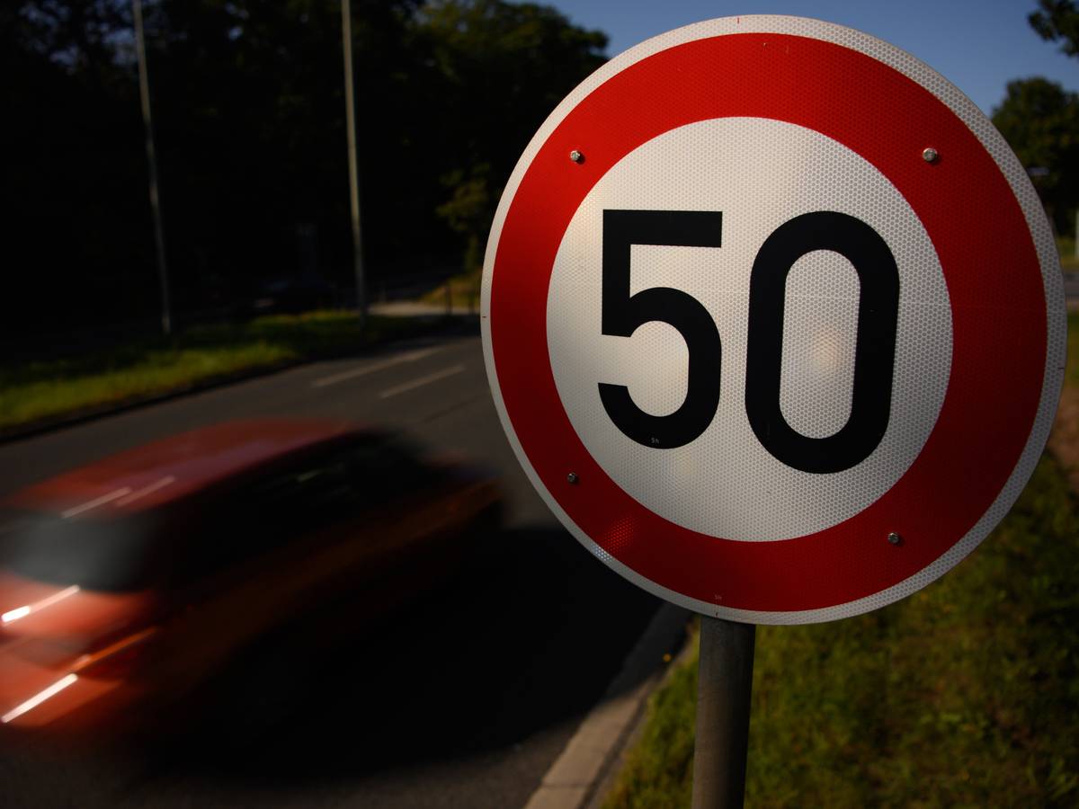 Ein Verkehrsschild zur Geschwindigkeitsbegrenzung auf Tempo 50 neben einer Straße