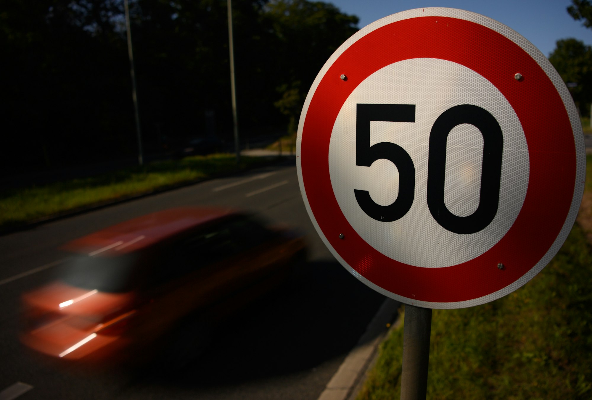 Ein Verkehrsschild zur Geschwindigkeitsbegrenzung auf Tempo 50 neben einer Straße
