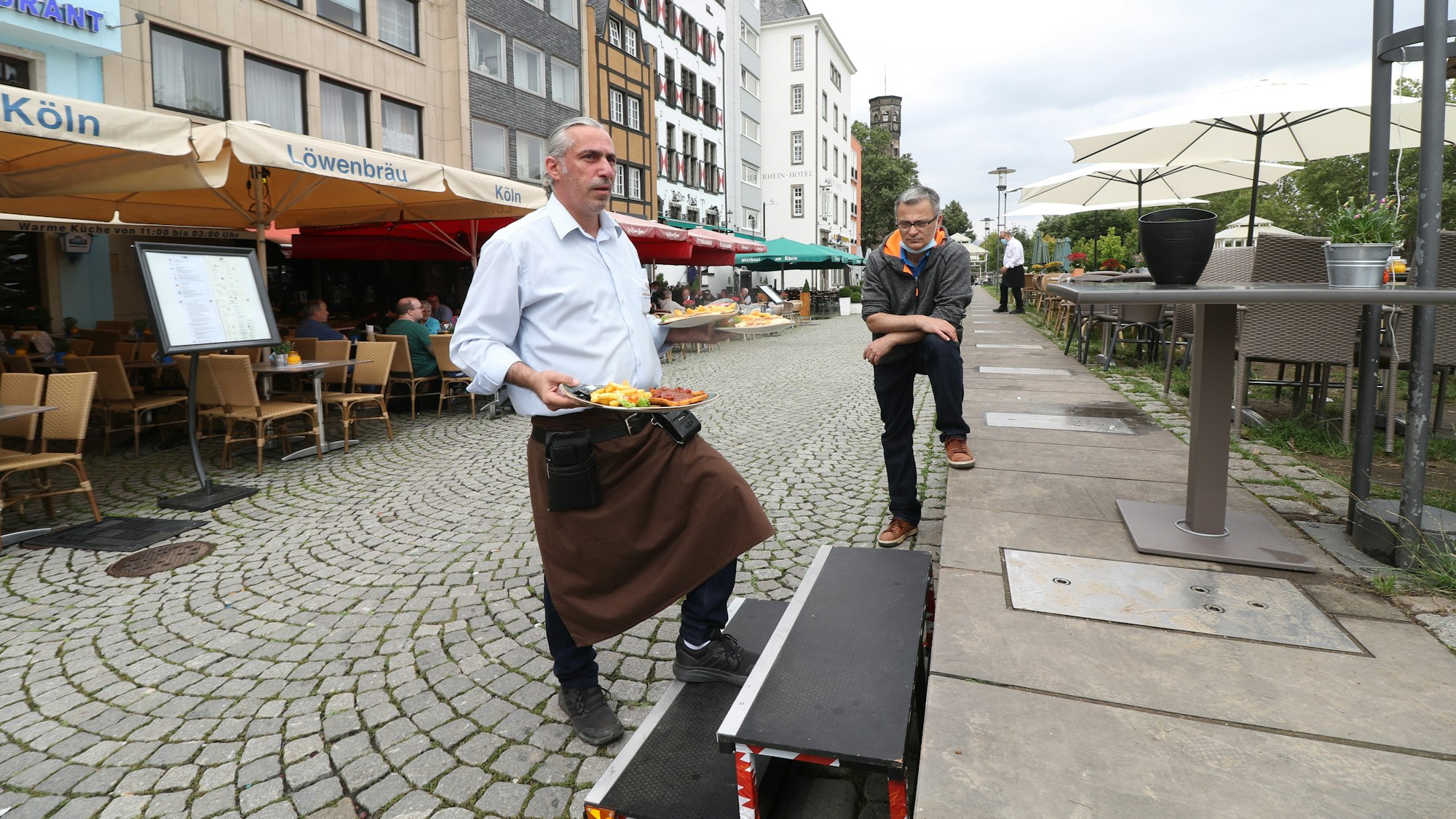 In der Kölner Altstadt nutzen Wirte eine kleine Treppe, um auf erhöhte Bereiche der Außengastronomie zu gelangen.
