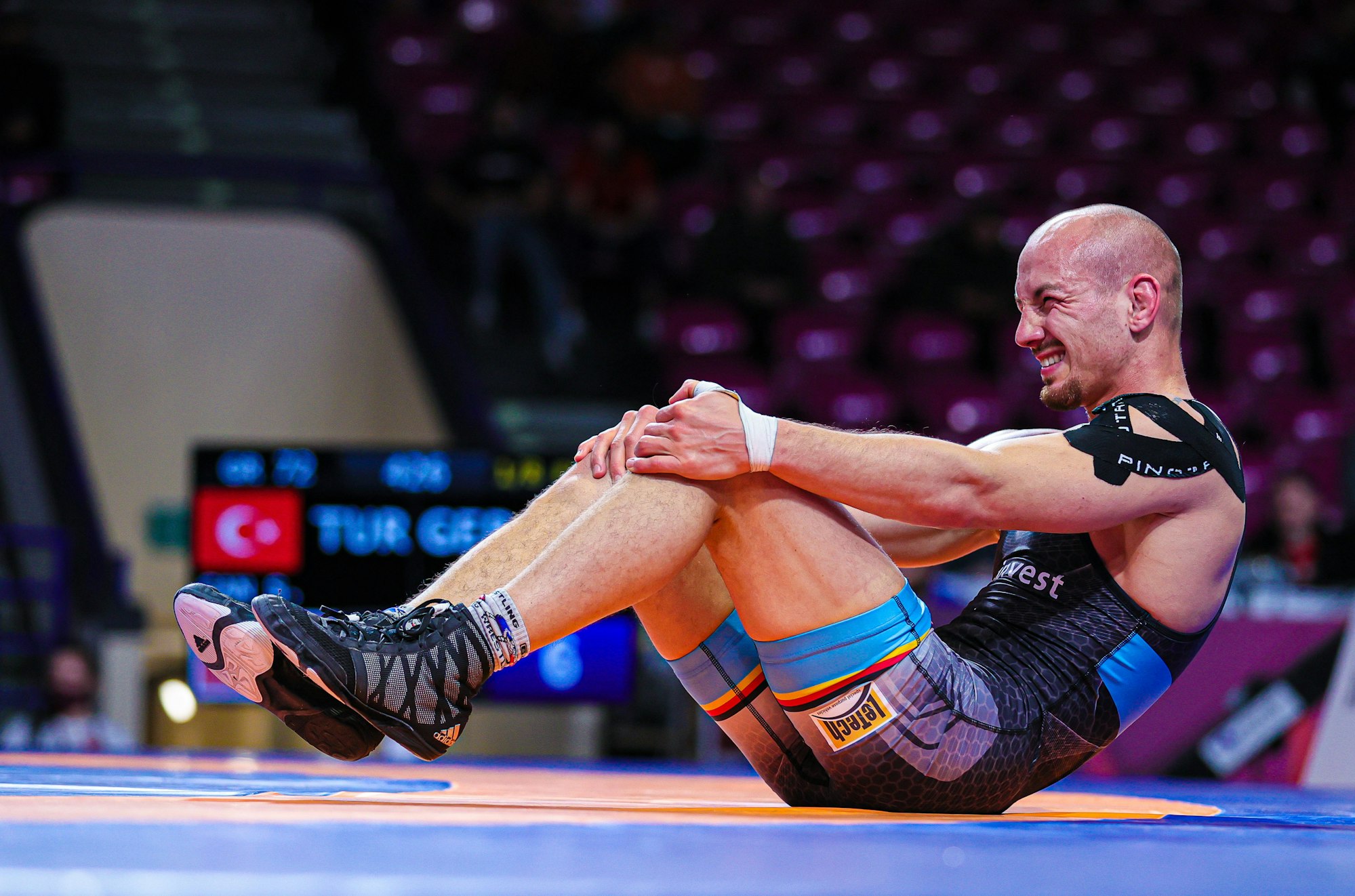 Deutschlands Ringer Frank Stäbler sitzt mit schmerzverzerrtem Blick auf dem Boden.