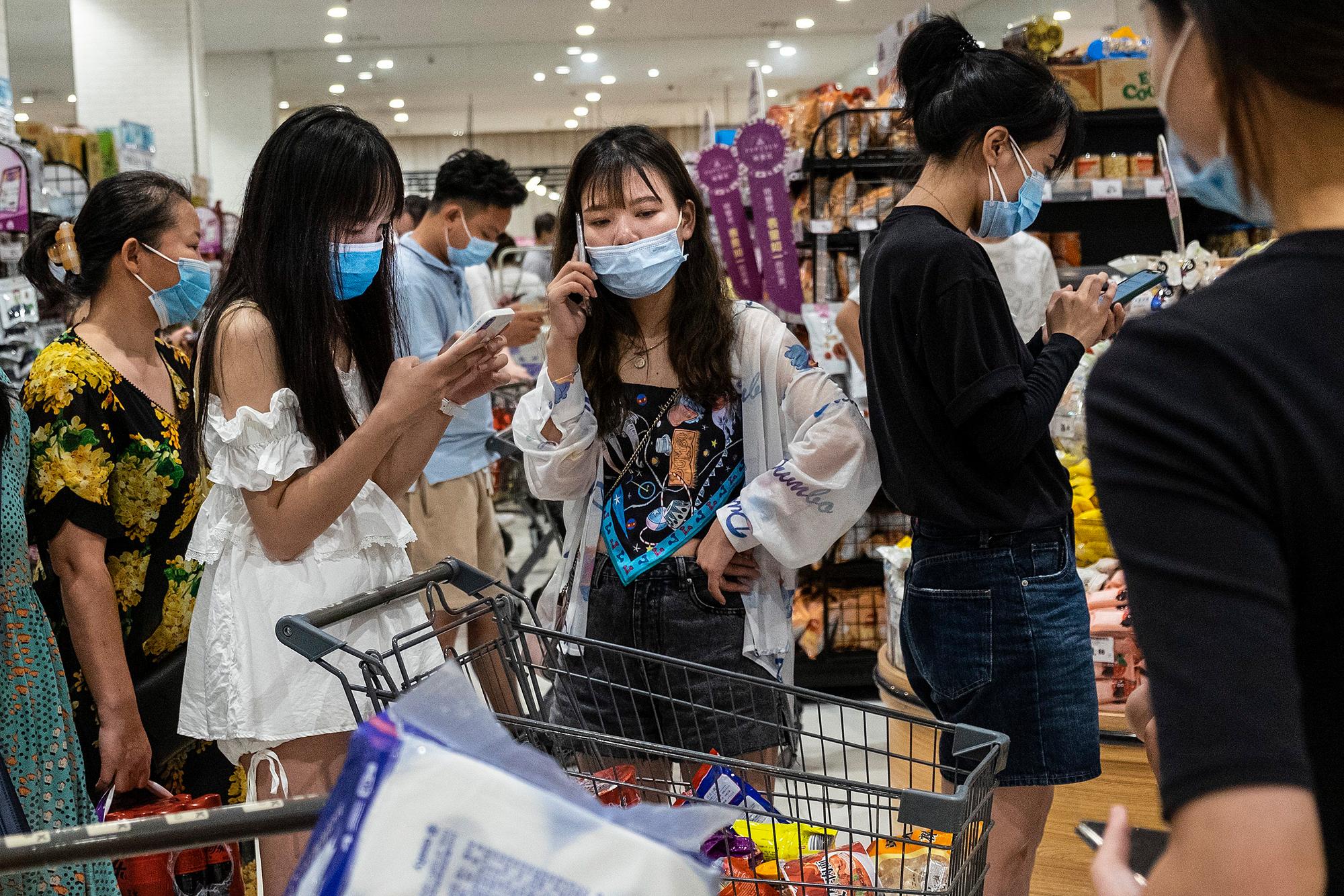 Menschen in einem Supermarkt im chinesischen Wuhan tragen am 02.08. Mund-Nasenschutz-Masken.